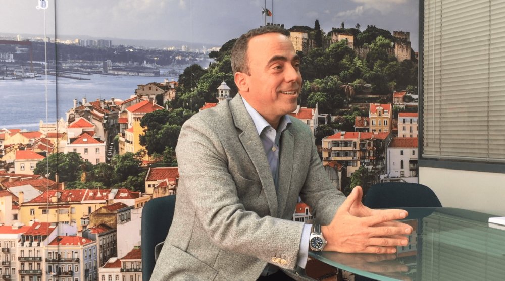 Pedro Fonseca sentado a uma mesa de reunião, conversando