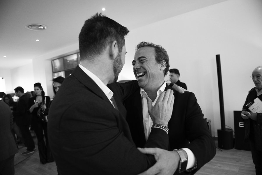 Pedro Fonseca rindo e apertando a mão de um convidado, num evento do Grupo Latina