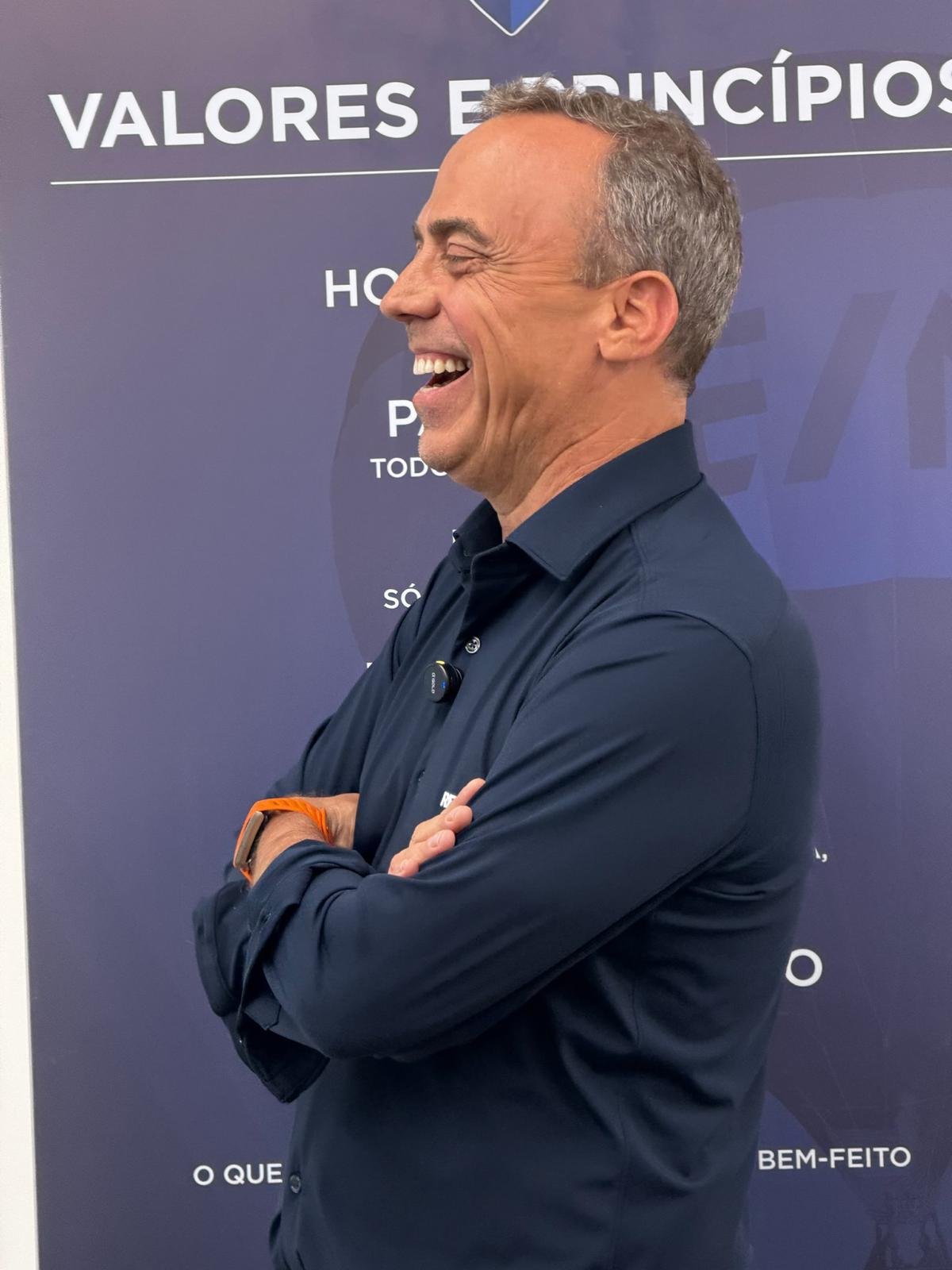 Pedro Fonseca rindo, diante do painel Valores e Princípios da RE/MAX
